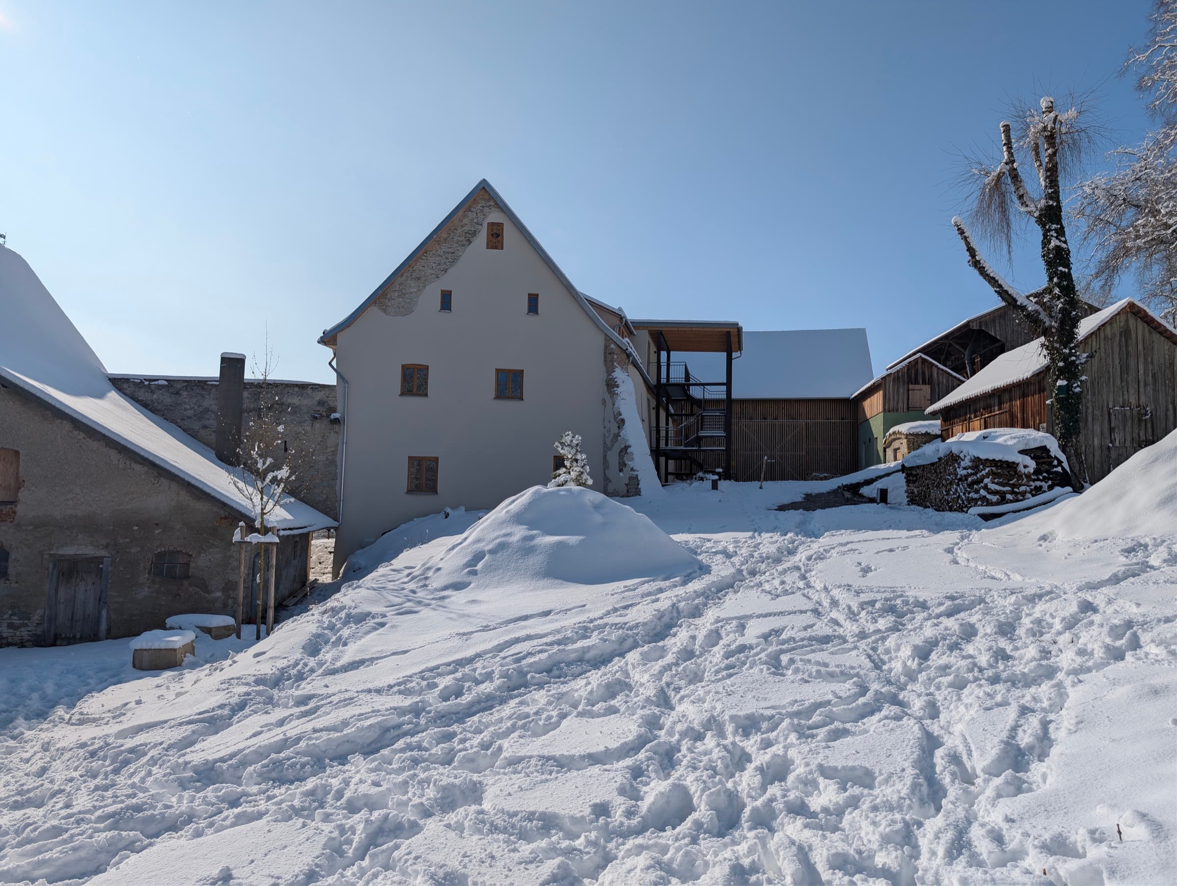 Denkmalgeschützter Gutshof Hofberg 1 in Obermässing im winterlichen Naturpark Altmühltal — verschneite Bruchsteinmauern, Satteldach, klarer Wintertag